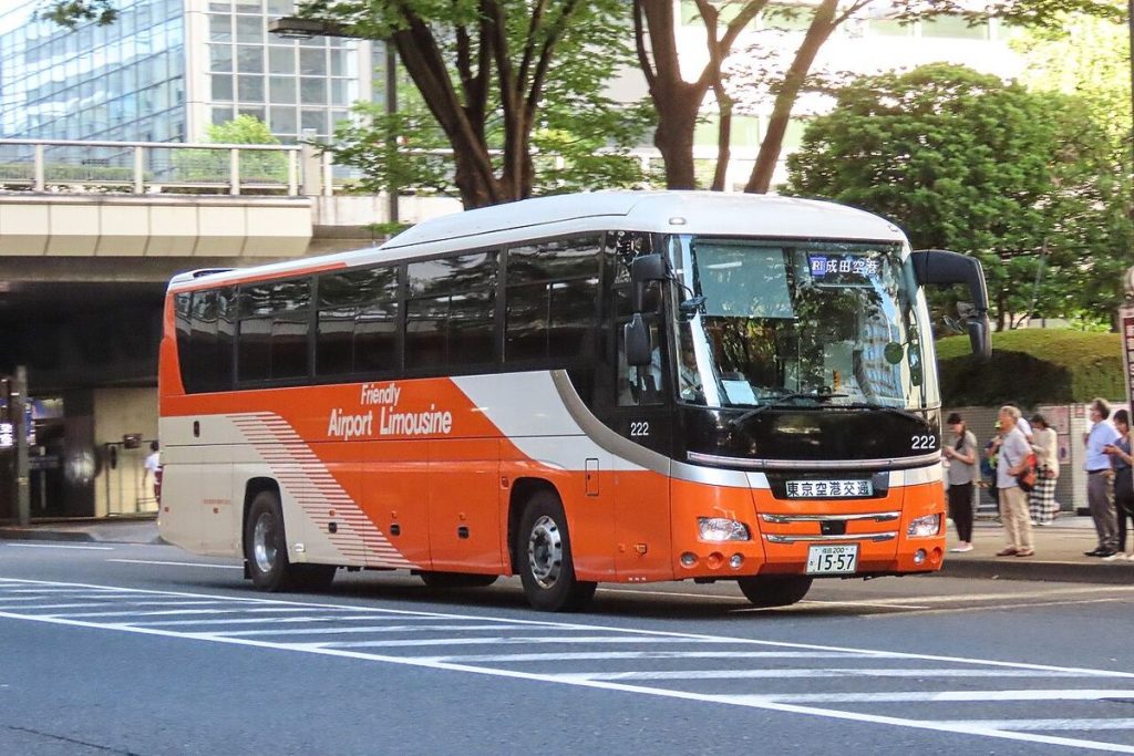 An orange and white Airport Limousine bus stopped at the Shinjuku NS Building in west Shinjuku