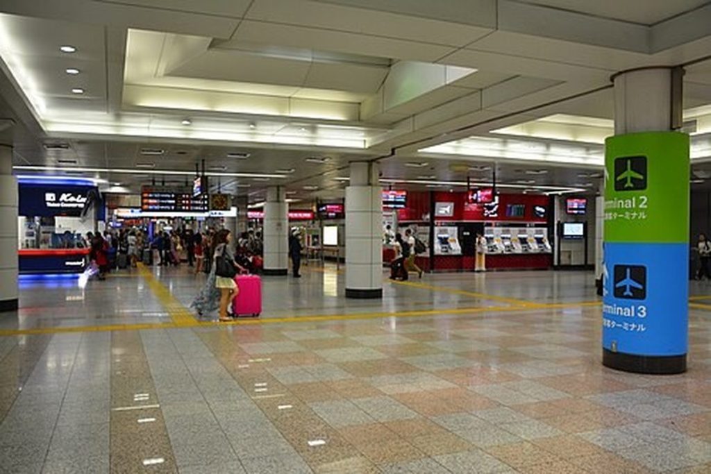 Bright station concourse at Narita Airport Terminal 2 with ticket machines and gates for trains into Tokyo