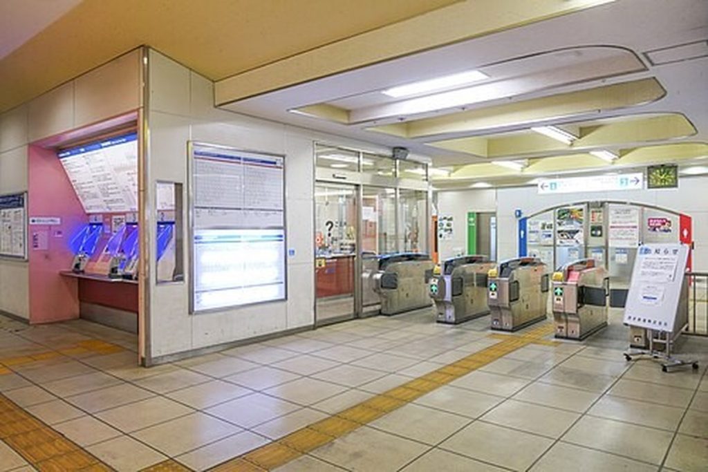 Small suburban station entrance with IC card ticket gates and a staffed window