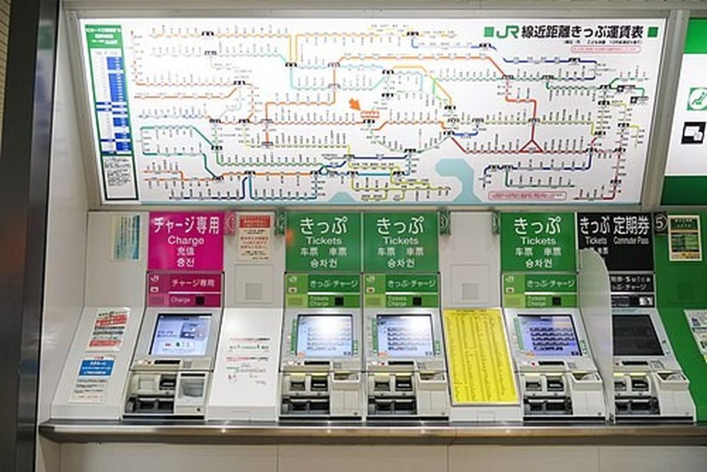 Row of JR ticket and IC card charge machines under a route map at Shin-Okubo Station