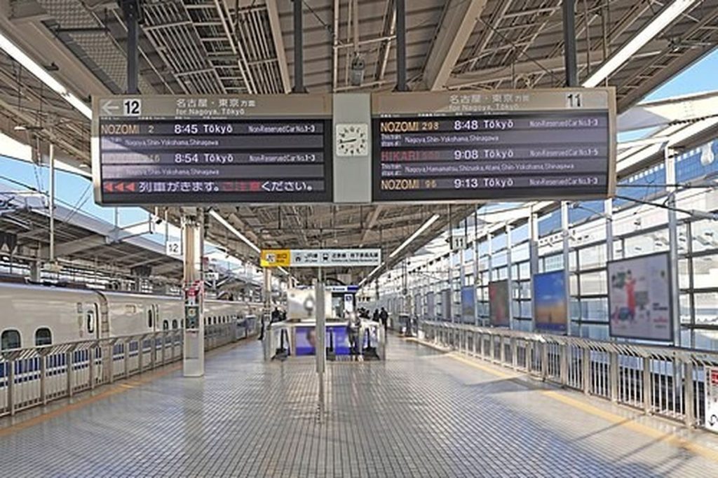 Long Shinkansen platform at Kyoto Station with departure boards overhead and platform screen gates