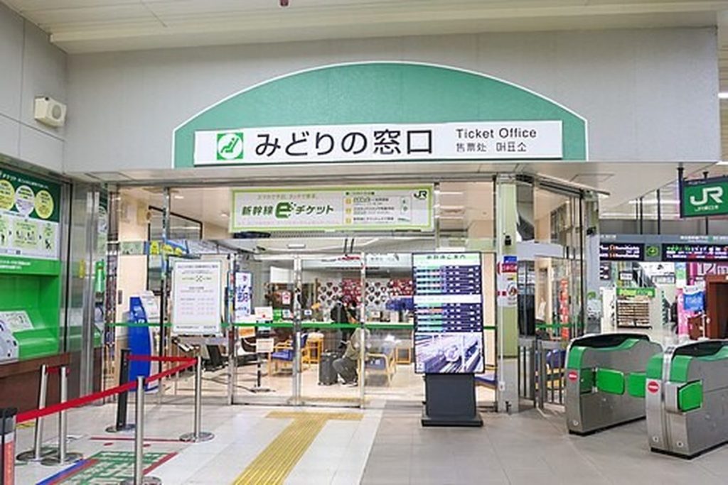 Entrance to a JR East ticket office with the green Midori-no-Madoguchi sign above the counters and ticket gates to the side