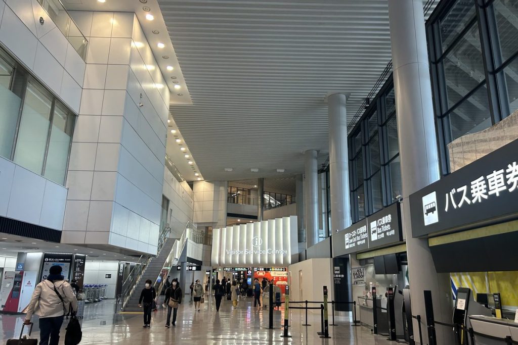 Narita Airport Terminal 1 arrivals hall with the bus ticket counter sign (バス乗車券) on the right