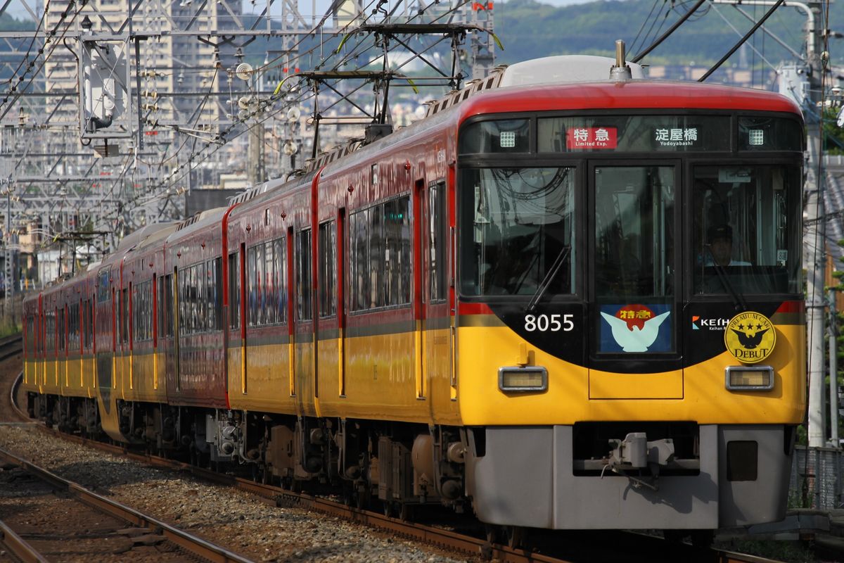 A red-and-yellow Keihan 8000 series Limited Express train, including its Premium Car, running on the Keihan Main Line
