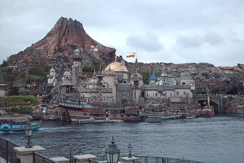 The volcano Mount Prometheus and harbour buildings at Tokyo DisneySea seen across the water