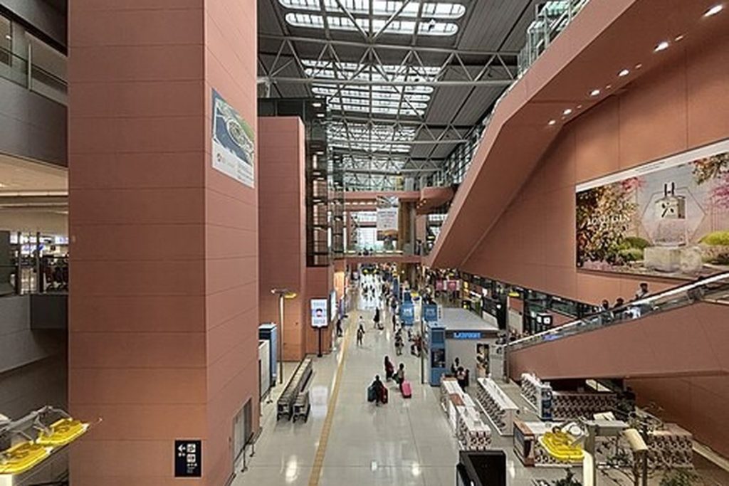 Arrival lobby atrium at Kansai International Airport with exits and information signs